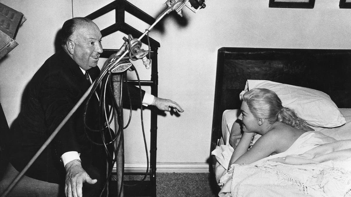 Alfred Hitchcock directs Kim Novak as she sleeps in bed
