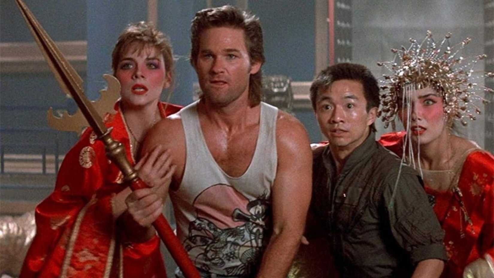 Kurt Russell as Jack Burton standing next to Wang, Gracie, and Miao Yin holding a spear in Big Trouble in Little China.