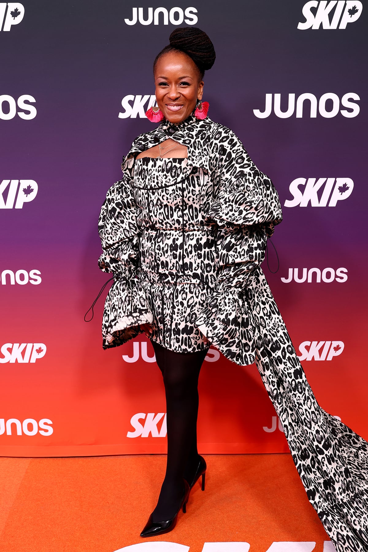 A woman poses for a photo in a black and white leopard print gown.