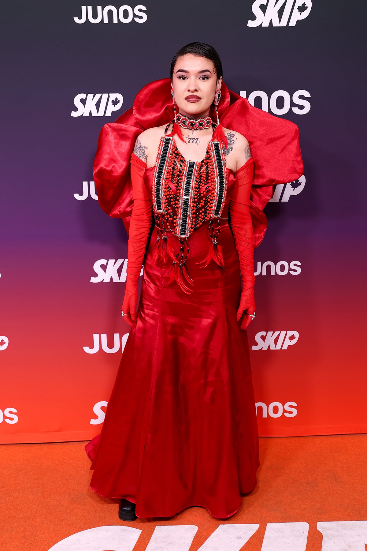 A woman poses for photos in a red ensemble.