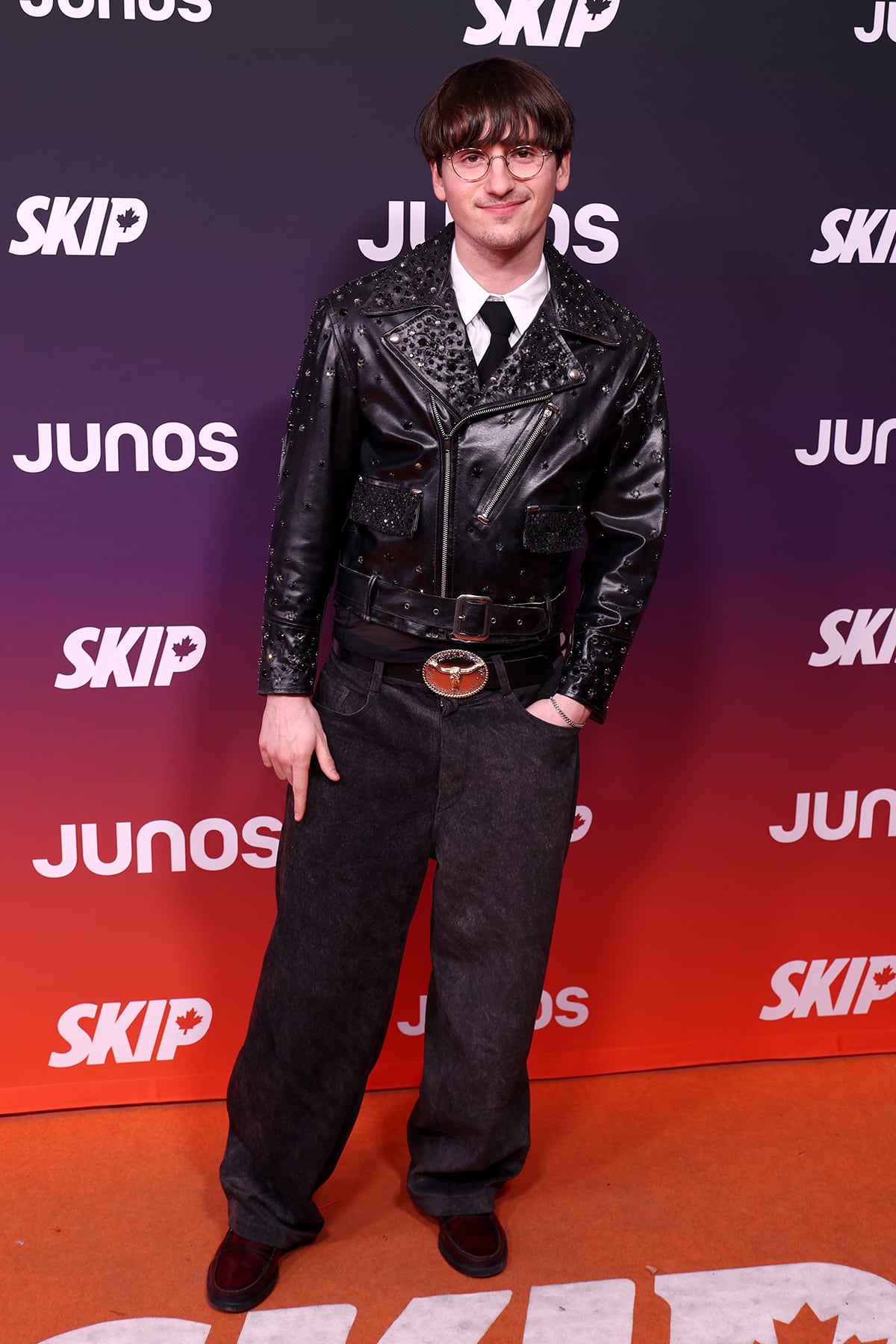 A man is standing on an orange carpet.