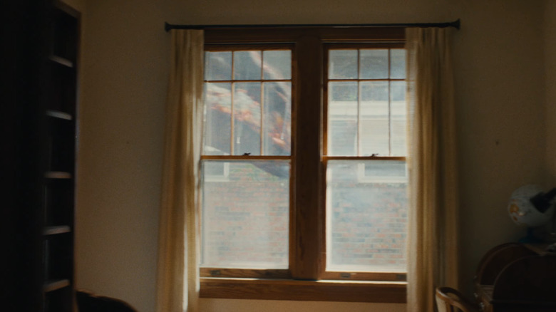 A dinosaur walking by the window on The End of Oak Street