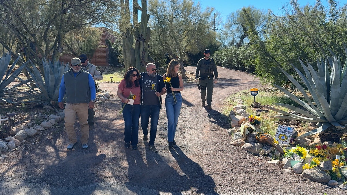 The Guthrie family places flowers at the home of Nancy Guthrie