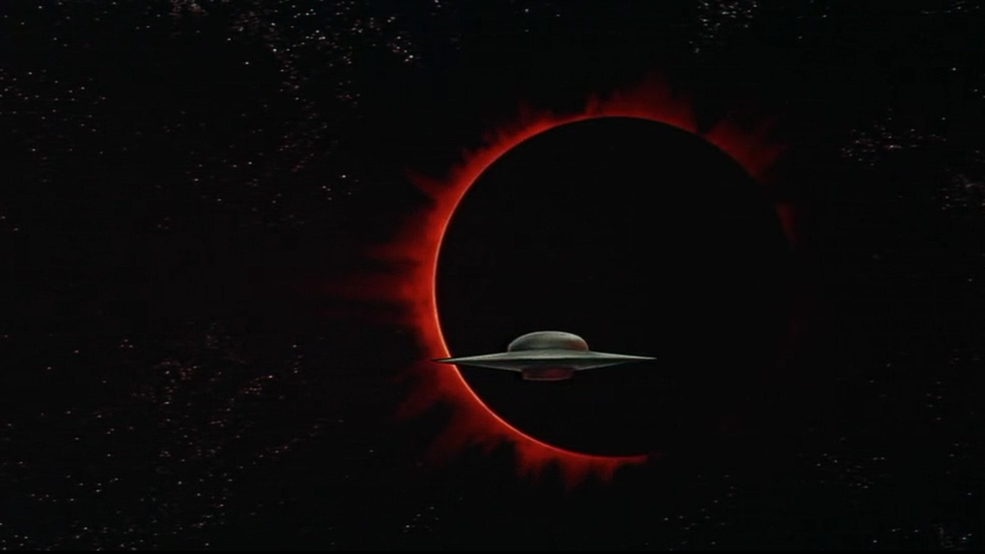 An image from the 1956 sci-fi film Forbidden Planet, showing a UFO against the dark background of a lunar eclipse.